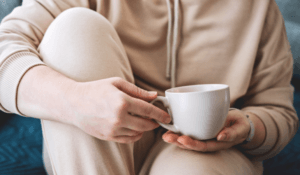 Person sitting with coffee cup in hand reflecting on her life